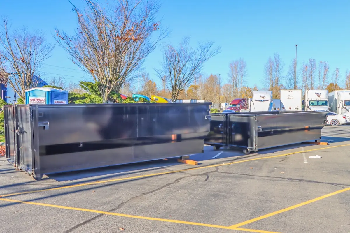 Professional dumpster rental service with roll-off container on residential driveway in Byron